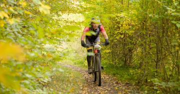 sportif sur VTT chemin en forêt automne